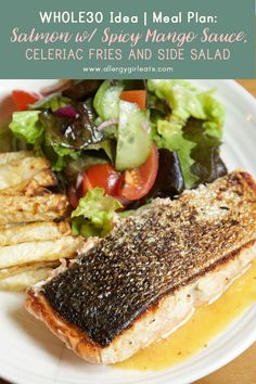 a white plate topped with fish and vegetables