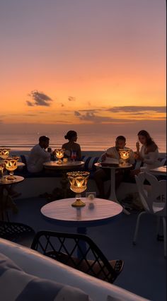 people sitting at tables on the deck of a cruise ship with candles lit in front of them