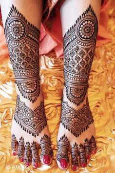 the legs and feet of a woman with henna tattoos