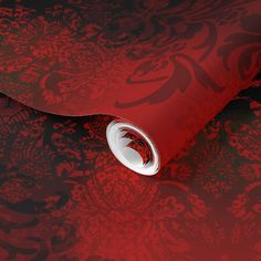 a red and black wallpaper with an intricate design on it's surface,