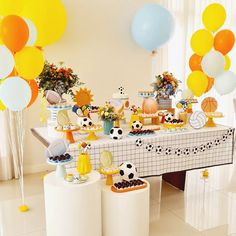 a table filled with lots of food and balloons