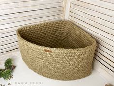 a large woven basket sitting on top of a white table next to pine cones and other items