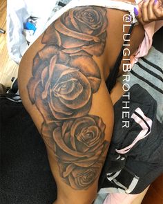 a woman's thigh with black and grey roses on it