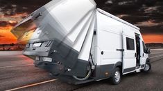 an rv is parked on the side of the road in front of a cloudy sky