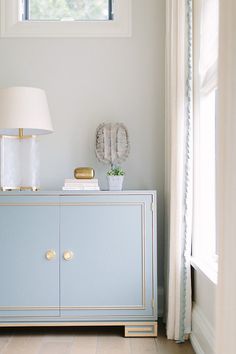 a white and blue cabinet with a lamp on top