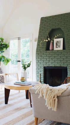 a living room filled with furniture and a fire place in front of a brick wall