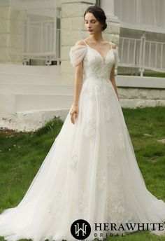 a woman in a wedding dress standing on the grass