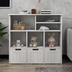 a white bookcase with four bins and two stuffed animals on the bottom shelf