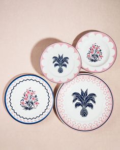 four plates with blue and pink designs on them