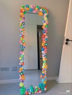 a large mirror decorated with colorful beads and candy balls in the shape of a rainbow