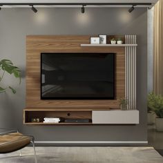 a living room with a television on the wall and plants in vases next to it