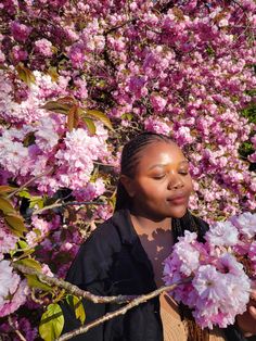 a woman standing in front of pink flowers