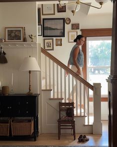 a woman is standing on the stairs in her home