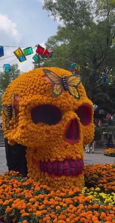 a large skull made out of flowers in the shape of a butterfly on it's head