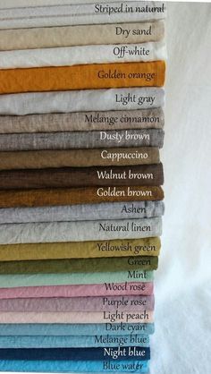 a stack of folded towels with different colors and names on them, all stacked together