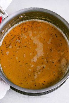 a bowl filled with soup on top of a white table cloth next to a fork