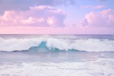 a man riding a wave on top of a surfboard in the ocean under a cloudy sky