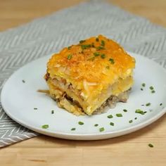 a piece of lasagna on a white plate with green garnishes