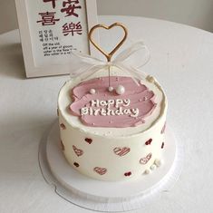 a birthday cake on a white table with chinese writing in the background and a card