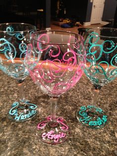 three wine glasses sitting on top of a counter next to each other in different colors