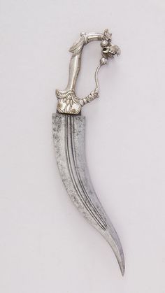 a silver object with a long blade attached to it's side on a white surface