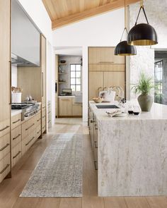 a kitchen with wooden cabinets and white marble counter tops, along with an area rug on the floor