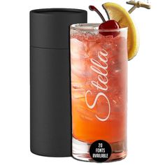 a tall glass with a cherry on the rim next to a black canister filled with liquid