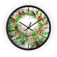 a clock with watercolor flowers and leaves painted on it's face, in the shape of a wreath