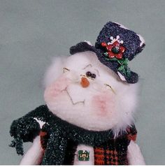 a snowman with a hat and scarf on it's head is posed in front of a gray background