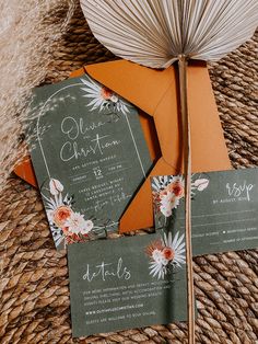 the wedding stationery is set on top of an orange envelope and some brown paper