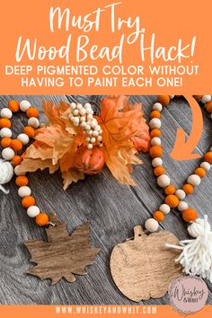 a wooden bead necklace with white and orange beads on it, next to an orange pumpkin