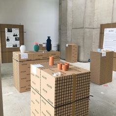 cardboard boxes and vases are stacked on top of each other in an empty room