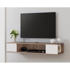 a flat screen tv mounted to the side of a white wall with shelves below it