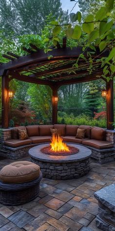 an outdoor fire pit surrounded by stone patio furniture and seating area with pergolated roof