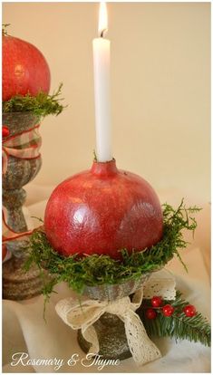 an apple candle holder is adorned with greenery and red apples for the centerpiece