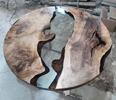 a table made out of wood and glass in the middle of a room with other pieces of furniture