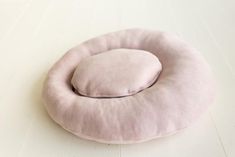 a pink pillow sitting on top of a white table