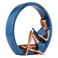 a figurine is sitting on the floor in front of a blue circular object