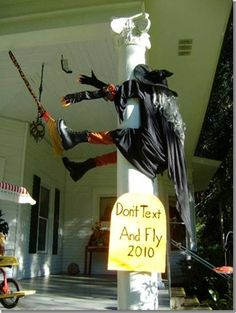 a scarecrow on a pole with a sign that says don't text and fly on it