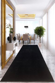 a large rug in the middle of a room next to a dining table and chairs