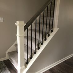 the stairs are made of wood and have black balconies on them, along with carpeted flooring