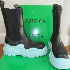 Here's A Brand New Pair Of Bottega Veneta Tire Boots, Here Done In Black Leather With Side Stretch Inserts And The Signature Wave Bottom Sides In A Pale Blue Hard Rubber. Retail Is $1450. The Most Recognizable Rain Boots On The Planet....But Why Wait Till It Rains? Sized 39.5, Comes With Shoe Box (The Corners Of The Box Have Been Taped.). Bottega Tire Boots Outfit, Designer Blue Boots With Round Toe, Blue Boots With Rubber Sole, Luxury Blue Boots With Round Toe, Chunky Boots Bottega Veneta, Botega Venetta Boots, Bottega Veneta Tire Boots, Bottega Veneta Tire Boots Men, Bottega Veneta Shoes