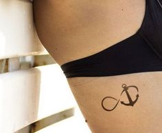 a woman's stomach with an anchor tattoo on her lower body and the word love written in cursive writing