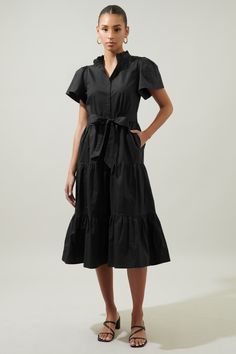 Vacay ready. Keep things light and effortless in the Bellucci Midi. Features a ruffle trim banded collar that meets a fully functional button front. Short circle sleeves frame a tiered midi skirt with pockets. A waist tie completes the look by adding shape. Wear it with rattan sandals and a wide brimmed hat for a full vacation ensemble.- Poplin- Waist tie- Button front- Pockets- Comes in 2 colorsSize + Fit - Model is 5'10" and wearing size S- Measurements taken from size S - Chest: 18 1/4"- Leng Black Tiered Midi Dress With Ruffle Hem, Midi Length Tiered Dress With Ruffle Hem For Daywear, Elegant Black Tiered Dress For Spring, Daywear Tiered Ruffle Midi Dress, Spring Workwear Dress With Tiered Skirt, Fitted Tiered Midi Dress For Work, Black Midi Dress With Ruffle Hem For Daywear, Chic Black Midi Length Tiered Dress, Fitted Midi Length Tiered Dress For Daywear