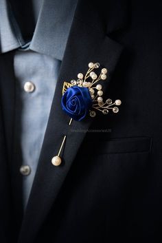 a blue lapel flower on a black suit with pearls and beads in the lapel