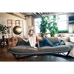 a man laying on top of a couch in a living room