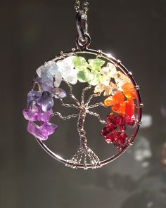 a tree of life pendant with seven colors in it