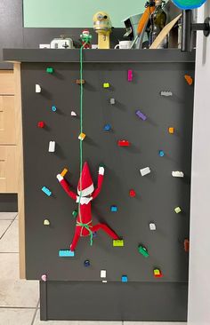 the elf is hanging on the wall with legos all over it's body