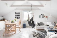 a living room filled with furniture and a hammock hanging from the ceiling