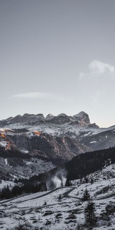 the mountains are covered in snow and clouds